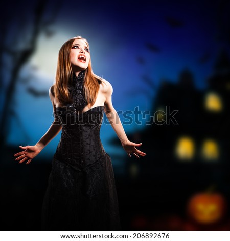 attractive vampire in front of a halloween house