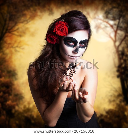 attractive young woman with sugar skull makeup and hair decoration made with roses