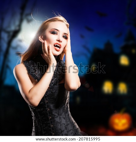attractive vampire in front of a halloween house