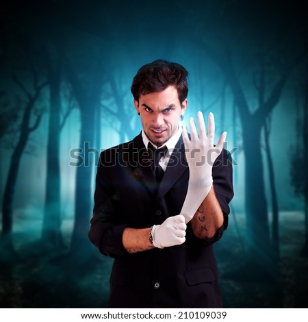 man in a suit puts medical gloves on, standing in front of a forest background