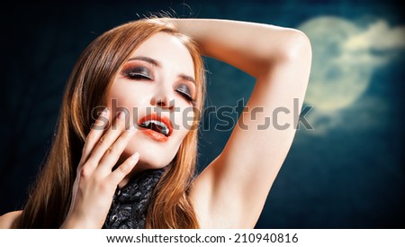 attractive vampire in front of a dark landscape with full moon