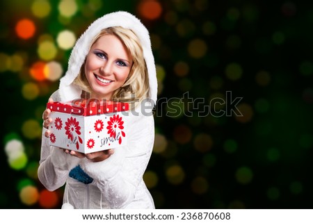 attractive blond woman in winter clothes with a gift box