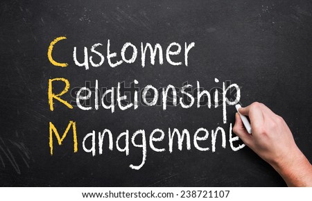 hand writing customer relationship management on a chalk board with the first letters in a different color