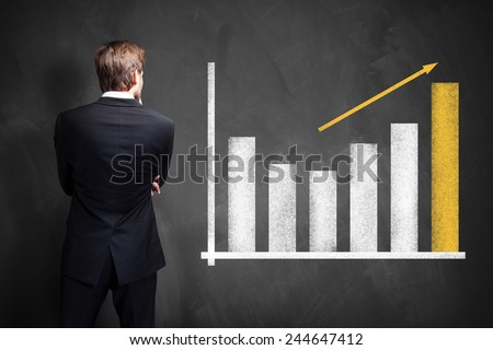 businessman looking at a growing info graph