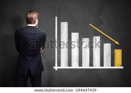 businessman looking at a declining info graph