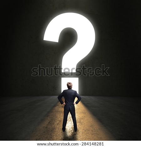 businessman standing in front of a portal shaped as a question-mark
