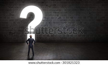 businessman standing in front of a portal shaped as a questionmark