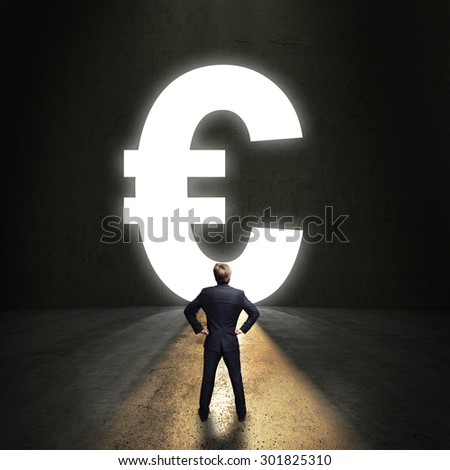 businessman standing in front of a portal shaped as a euro-symbol