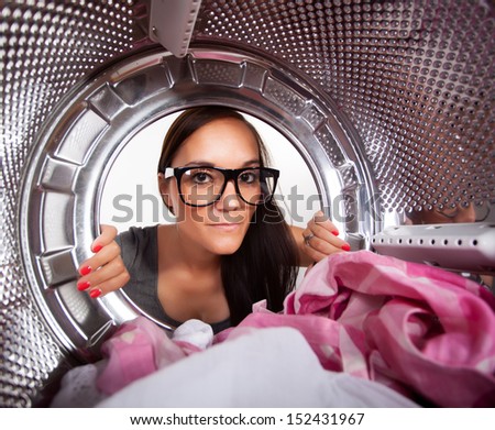 Young man doing laundry View from the inside of washing machine.