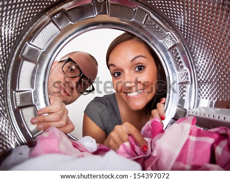 Young couple doing laundry View from the inside of washing machine.