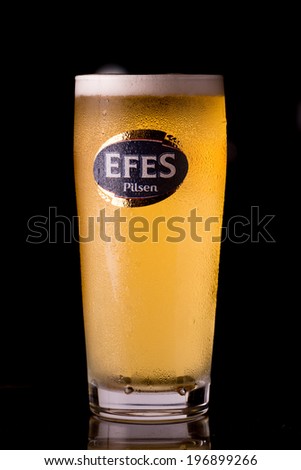 Belek, Turkey-June 3, 2014: An Efes beer glass on the bar. Efes Beverage Group, named after the ancient city of Ephesus, is market leader in Turkey, Moldova, Georgia, and in Top5 in other EU countries