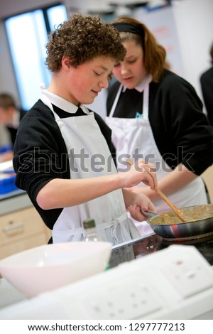 Male high school student cooking in home economics class