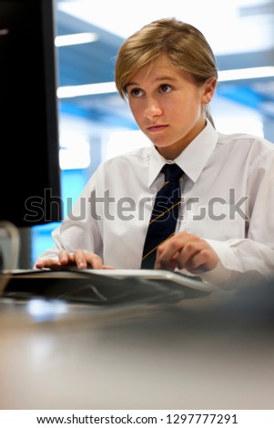 Female high school student in uniform in computer science lesson