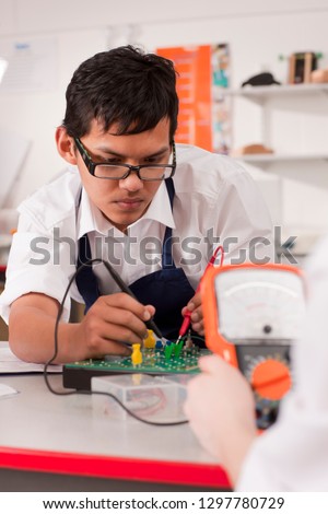 Male high school students studying electronics in class