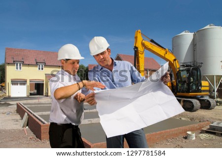Construction workers discussing plans on house construction site
