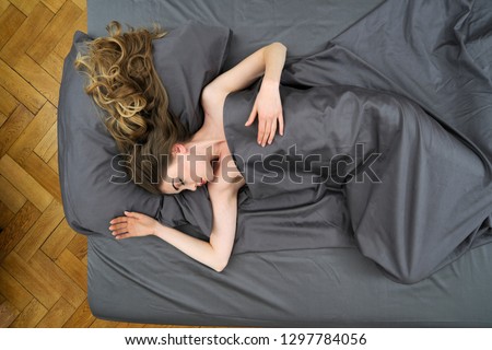 Overhead view of young woman sleeping in bed at home