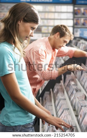 Young couple choosing CD's in record shop, side view