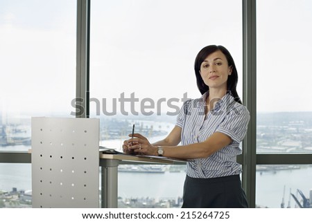 England, London, Canary Wharf, businesswoman standing behind lectern, giving presentation