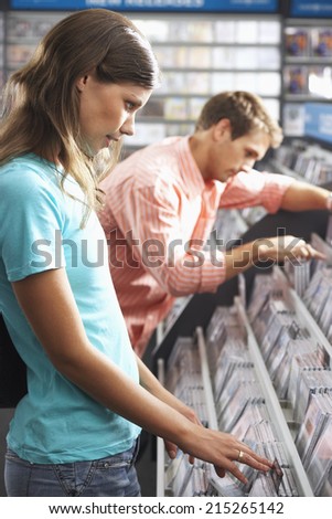 Young couple sifting through CDs in record shop, side view