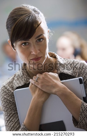 Businesswoman carrying laptop, close-up, front view, portrait, focus on foreground
