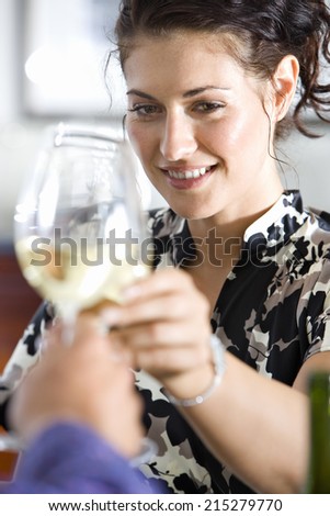 Couple toasting wine glasses, woman smiling, close-up