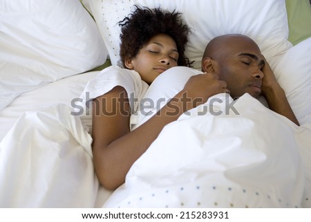 Young couple asleep in bed, elevated view