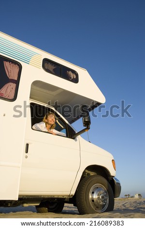 Mature woman looking out window of motor home, low angle view