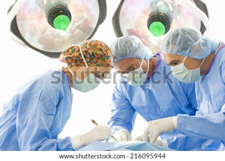 Surgeons operating on patient, low angle view