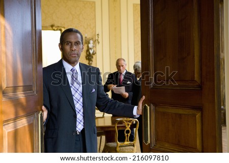Businessman shutting doors of office, portrait