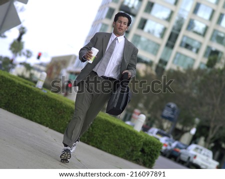 Businessman in running shoes with bag and coffee (tilt)