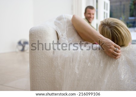 Couple on sofa wrapped in plastic