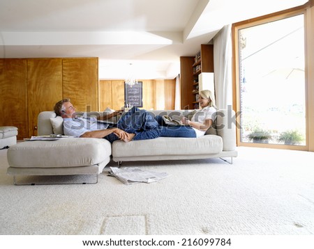 Couple on sofa, man with laptop computer, side view