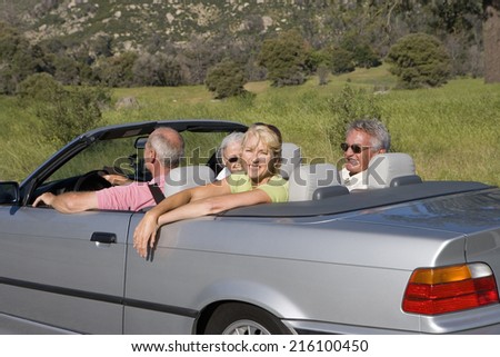 Senior couple with friends in convertible car