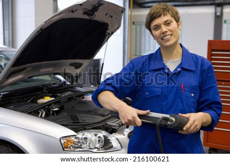 Female mechanic with electronic diagnostics device, portrait