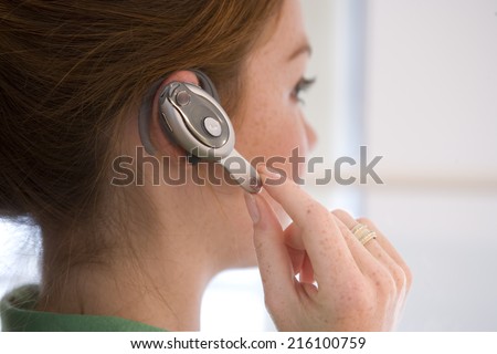 Woman with hands free device, side view