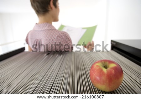 Businesswoman with file, apple on filing cabinet