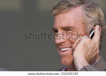 Businessman talking on hands-free cell phone device