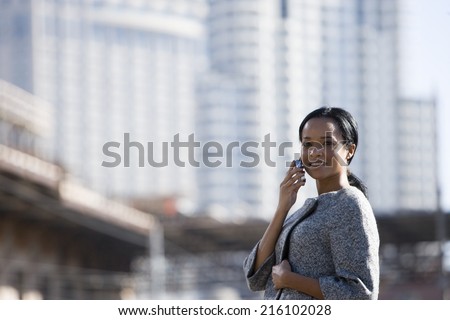 Businesswoman talking on cell phone in urban setting