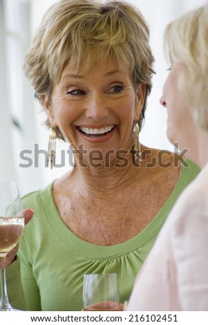 Senior woman with glass of wine, smiling, close-up