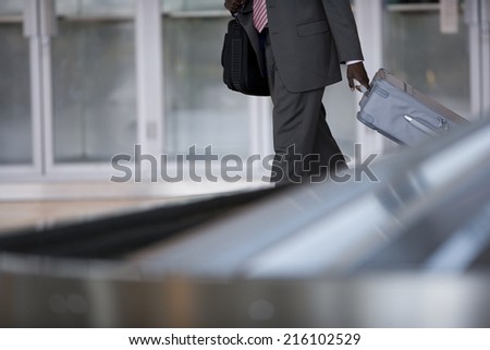Businessman removing suitcase from luggage carousel in baggage claim