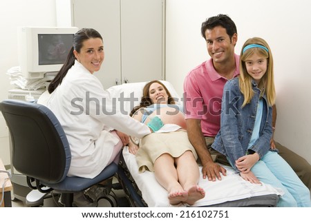 Young mother and family at pregnancy ultrasound examination