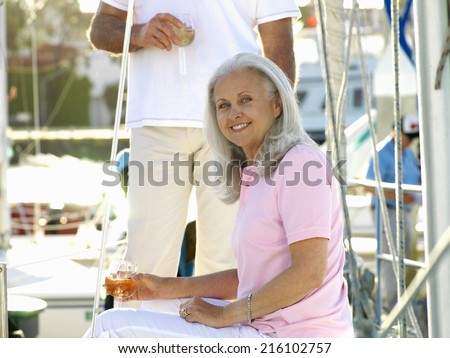 Senior woman on boat drinking white wine