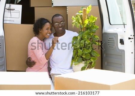 Couple unloading boxes from van