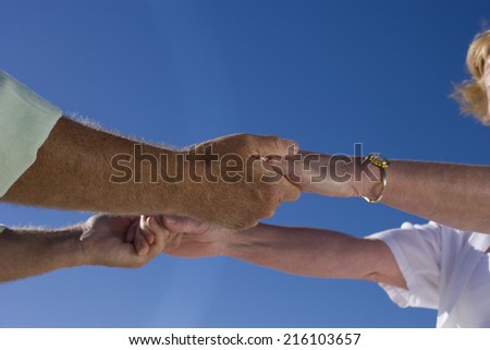 Mature couple holding hands, close-up of hands
