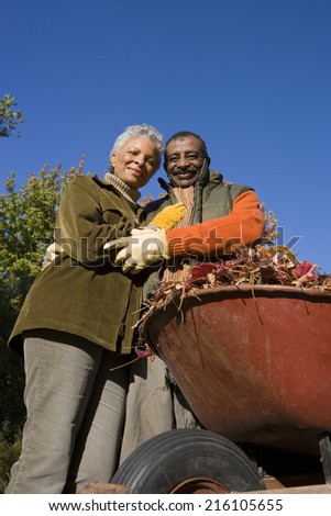 Senior couple doing yard work in autumn