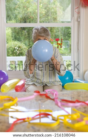 Woman blowing up birthday balloons