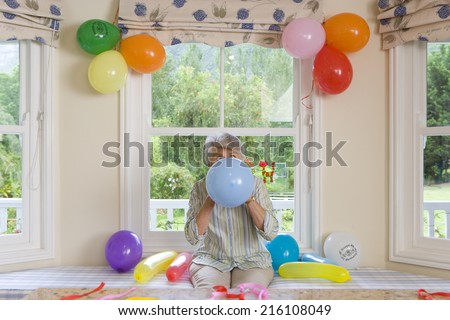 Woman blowing up birthday balloons