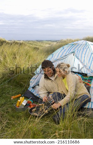 Young couple cooking at campsite