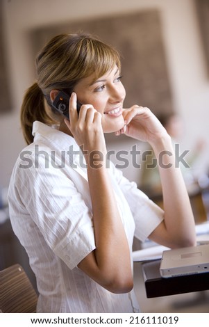 Businesswoman talking on cell phone in cafe