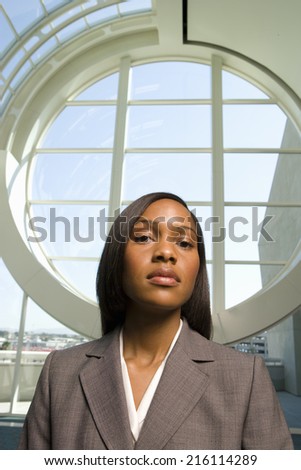 Businesswoman standing in front of round window